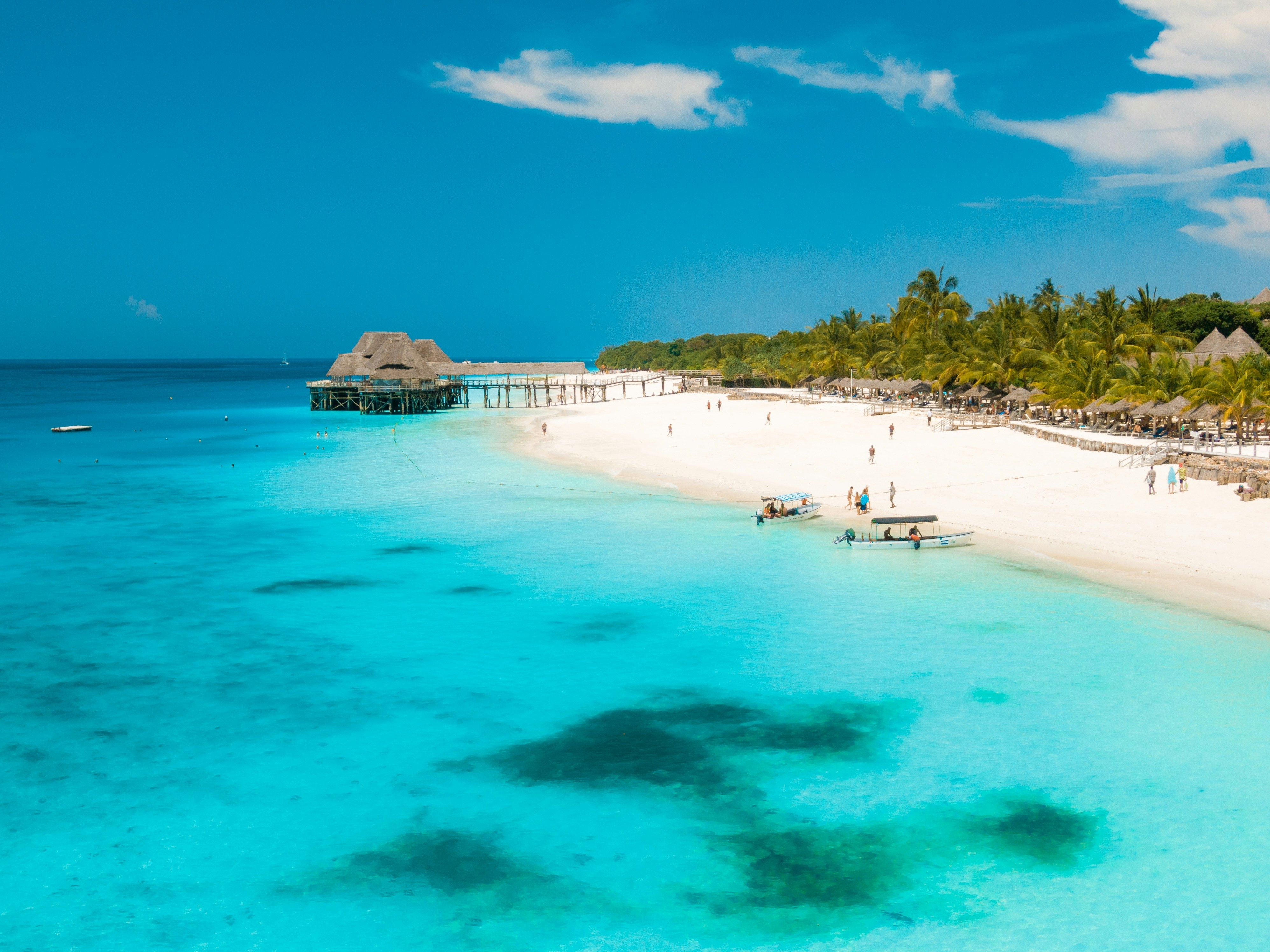 Quiet Indian Ocean beach with warm water and a distant sail